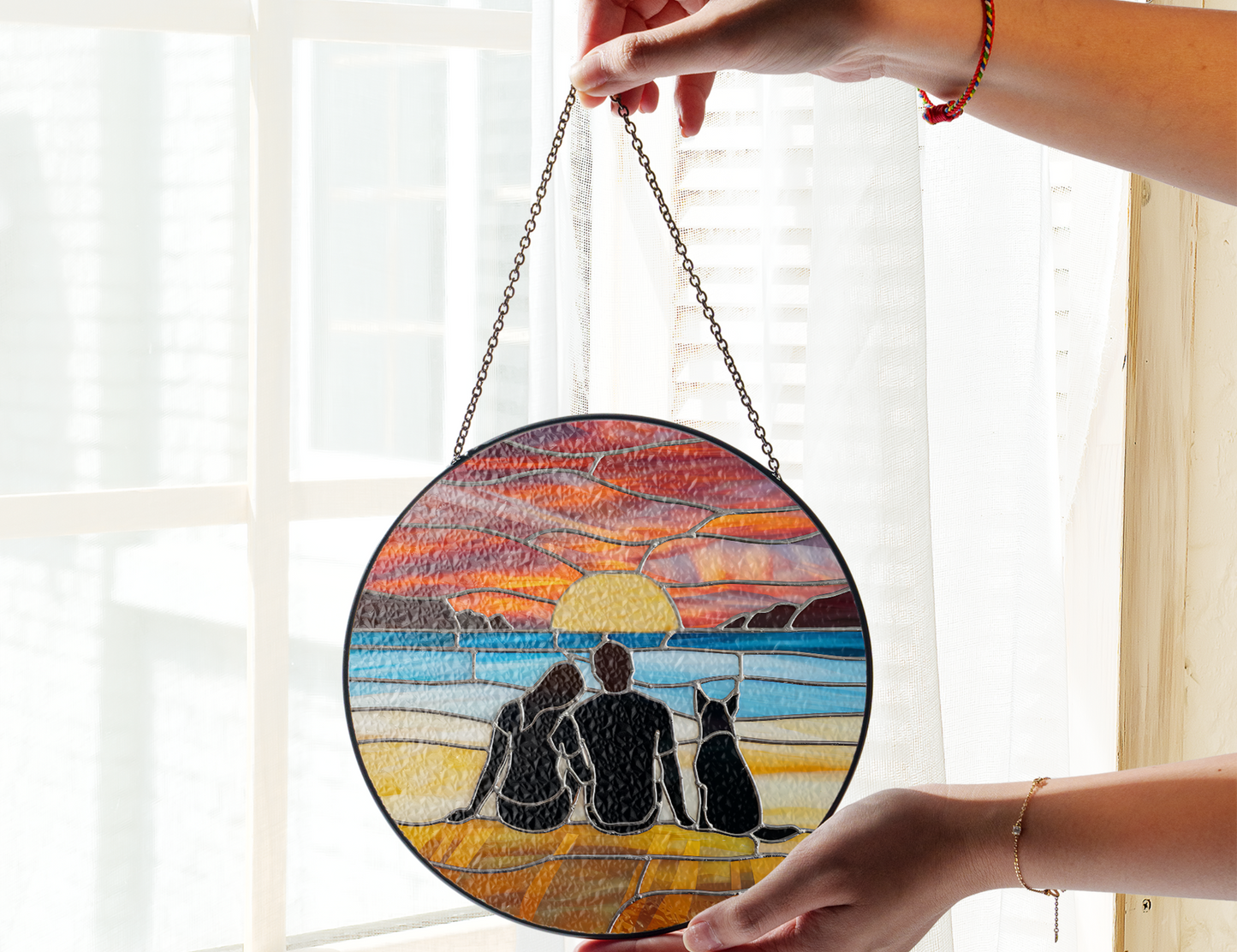 couple and dog at beach at sunset suncatcher in front of window