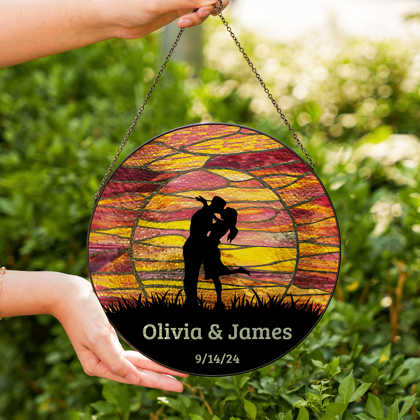 kissing couple at sunset suncatcher in two hands