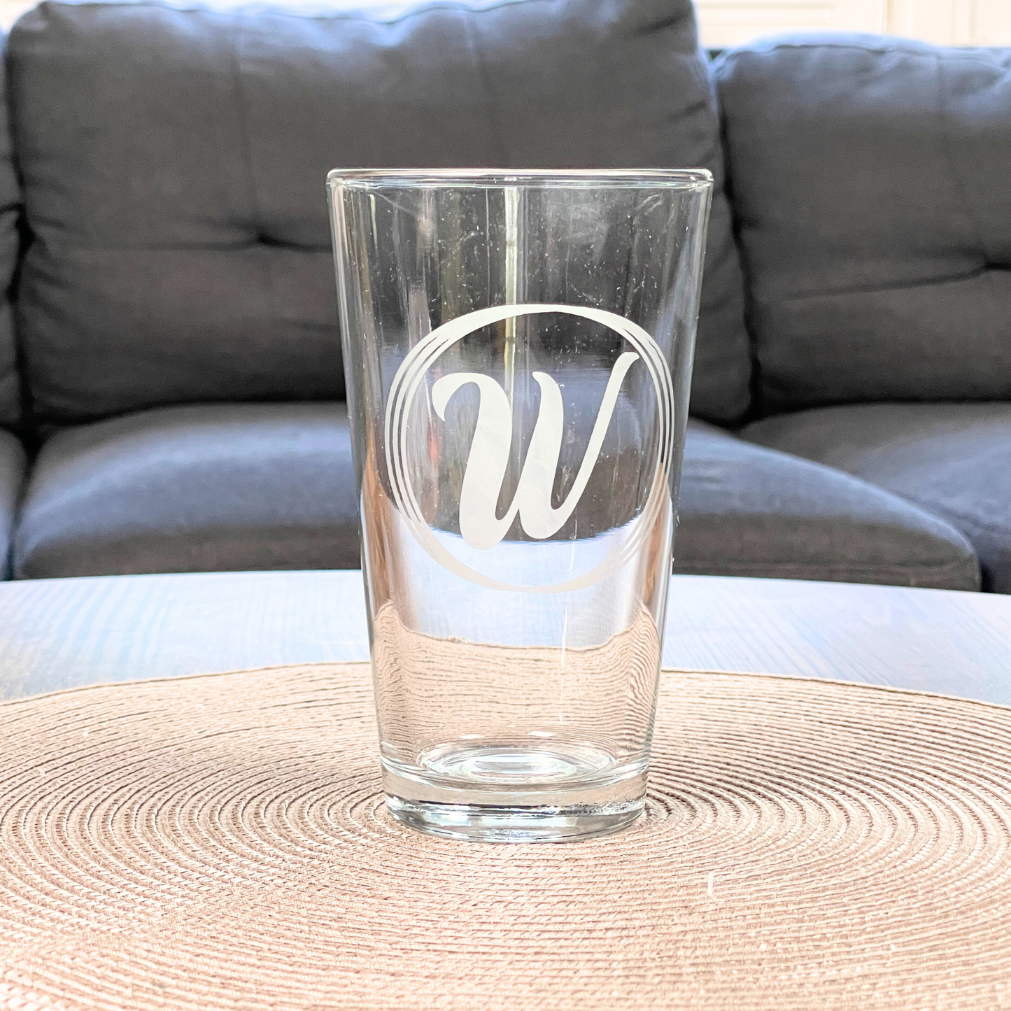 personalized pint glass with initial in a circles in living room