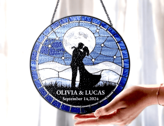 kissing couple under full moon suncatcher in front of window