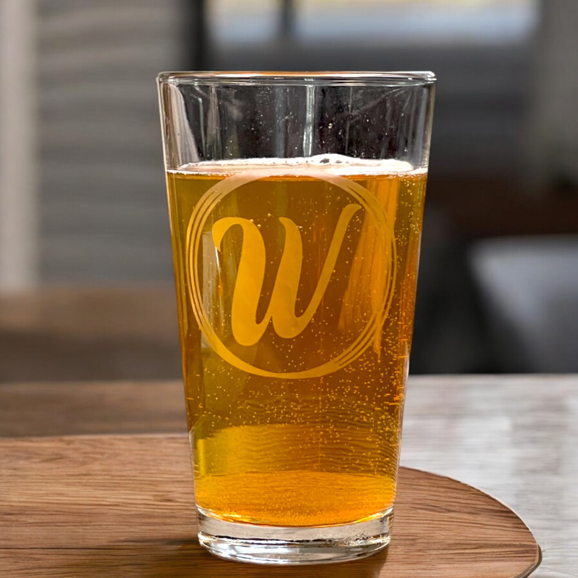 personalized pint glass with initial in a circles on a table