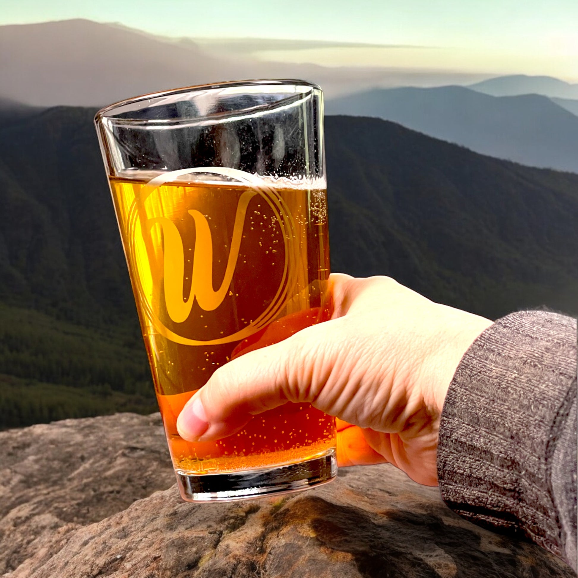 hand holding personalized pint glass with initial in a circles